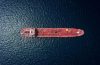 Aerial view of a red tanker ship sailing on dark blue water from above.